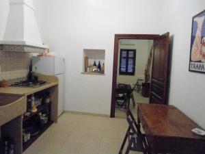 a kitchen and dining room with a table and a refrigerator at Residence Marsala Antica in Marsala