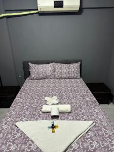 a bed with a purple bedspread with towels on it at URAZ Apart in Bursa