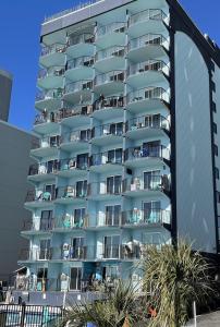 een hoog appartementencomplex met palmbomen ervoor bij Blue Palmetto in Myrtle Beach