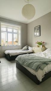 a bedroom with two beds and a window at ApartmentInCopenhagen Apartment 1599 in Hellerup