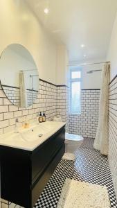 a bathroom with a sink and a mirror and a toilet at ApartmentInCopenhagen Apartment 1599 in Hellerup