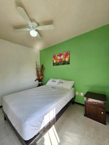 a bedroom with a white bed and a ceiling fan at Sensity Home Casa Novedosa Céntrica y Linda in Tehuacán