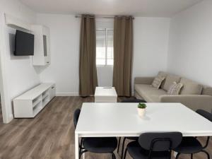 a white living room with a white table and chairs at Apartamento Torre del Castillo in Sanlúcar de Barrameda