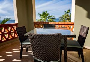 a table and chairs on a balcony with the ocean at Paraiso del Mar Condominiums in Misiones de La Paz