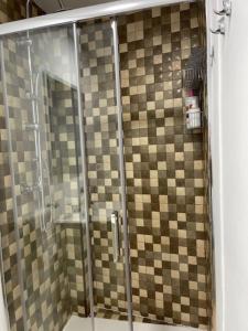 a bathroom with a shower with a tiled wall at Apartamento Torre del Castillo in Sanlúcar de Barrameda