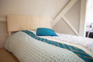 a bed with a blue pillow on top of it at ++++ CENTRAL COSY DUPLEX ++++ A 5 MIN DES REMPARTS ET 12 MIN DE PLACE DALTON A PIEDS in Boulogne-sur-Mer