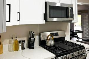 a kitchen with a stove top oven with a microwave at Modern Home Near Ontario Airport in Ontario