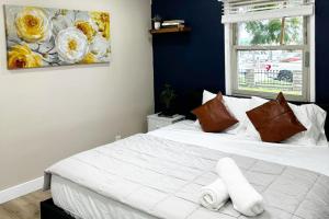 ein Schlafzimmer mit einem weißen Bett und einem Gemälde an der Wand in der Unterkunft Modern Home Near Ontario Airport in Ontario + 12 Fotos