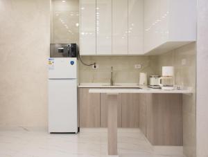 a kitchen with a white refrigerator and cabinets at Prestige hotel apartment in Amman