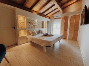 - une chambre avec un lit dans un dortoir doté de parquet dans l'établissement Gite de Saint Florent - Piscine & Spa, à La Charrière