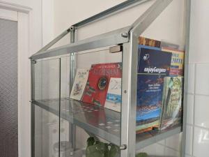 une étagère en verre avec des livres au-dessus dans l'établissement Camera a Sud - Lake Lesina, à Lesina