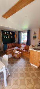 ein Wohnzimmer mit einem Sofa und einem Tisch in der Unterkunft Mobil-home Le cocon in Canet-en-Roussillon