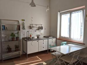 - une cuisine avec un évier et une table dans l'établissement Camera a Sud - Lake Lesina, à Lesina