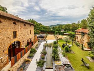 an outdoor patio with a garden and a building at Sweet SECRET'S JACUZZI in Le Breuil