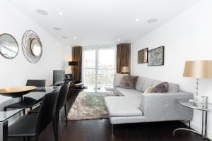 ein Wohnzimmer mit einem Sofa und einem Tisch in der Unterkunft Gorgeous Central 2BR Flat, Belgravia, Chelsea in London