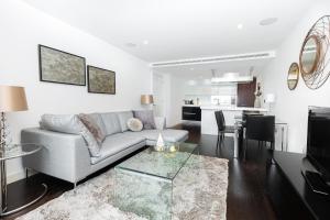 ein Wohnzimmer mit einem Sofa und einem Tisch in der Unterkunft Gorgeous Central 2BR Flat, Belgravia, Chelsea in London