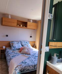 een slaapkamer met een bed in een kleine kamer bij Mobil-home Le cocon in Canet-en-Roussillon