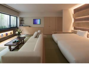 a bedroom with a large white bed and a couch at THE JUNEI HOTEL KYOTO - Vacation STAY 08693v in Kyoto