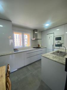 a large kitchen with white cabinets and appliances at Apartamento Vadillos - VuT 09-401 in Burgos