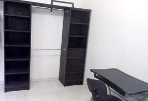 Cette chambre comprend un réfrigérateur, un bureau et des chaises. dans l'établissement Apartamento Las Flores Mérida, à Mérida