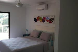 a bedroom with a bed and some butterflies on the wall at Apartamento Sorocotuba Guaruja in Guarujá