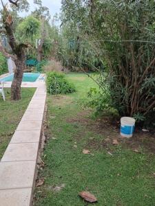 um jardim com uma piscina e um relvado com um balde em M L em Navarro