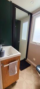 a bathroom with a sink and a large mirror at Mobil-home Le cocon in Canet-en-Roussillon
