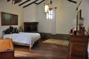 a bedroom with a bed and a table and a window at Valle Dorado Lodge in Cusco