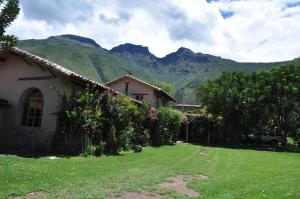 una casa con un patio con montañas al fondo en Valle Dorado Lodge, en Cusco