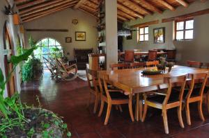 een eetkamer met een houten tafel en stoelen bij Valle Dorado Lodge in Cuzco