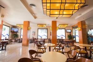 a restaurant with tables and chairs and a large chandelier at Hotel Costa Brava in Blanes