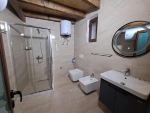 a bathroom with a shower and a sink and a toilet at Hotel Demaj in Berat