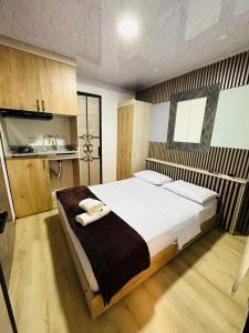 1 dormitorio con 1 cama grande y toallas. en Hotel Lares 70 Laureles en Medellín