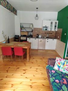 a living room with a wooden table and a kitchen at Pod Papugami in Srebrna Góra