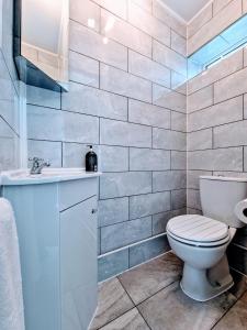 a bathroom with a toilet and a sink at Modern And Spacious 3 Bedroom Family House with Workspace in Colchester