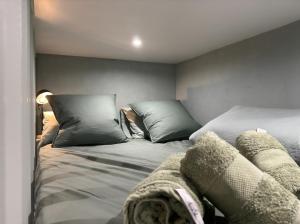 a bedroom with two beds with pillows at L'olivier Studio Lumineux avec agréable terrasse in Fécamp