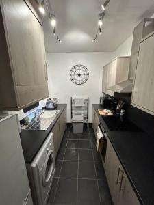 a kitchen with a sink and a clock on the wall at 3 Bedroom Home From Home, Crewe in Crewe