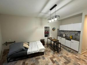 a bedroom with a bed and a table and a kitchen at La dimora di Pino in Ripa