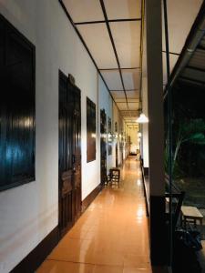 um corredor de um edifício com mesas e cadeiras em Thakhek Travel Lodge em Thakhek