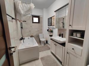 a white bathroom with a sink and a toilet at Mega Residence in Târgovişte