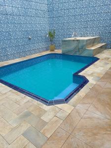 uma grande piscina com uma fonte num quarto em Casa Mongagua em Mongaguá