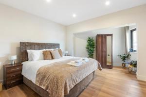 a bedroom with a large bed with a wooden floor at Modern One Bedroom Flat in Morden SM4, London in Morden