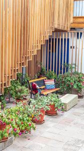 um banco sentado ao lado de um monte de vasos de plantas em Quinta San Blas by Ananay Hotels em Cusco