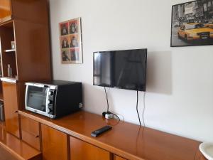 - une télévision installée au-dessus d'une table avec un four micro-ondes dans l'établissement La casa delle farfalle, à Seregno