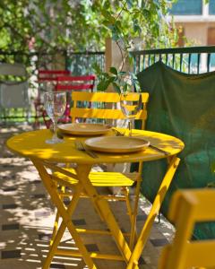 une table jaune avec deux verres à vin dans l'établissement Charming apartment with balcony and panoramic view, à Aix-en-Provence