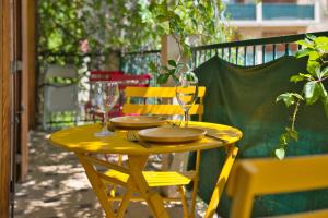 ein gelber Tisch mit zwei Gläsern und Platten darauf in der Unterkunft Charming apartment with balcony and panoramic view in Aix-en-Provence