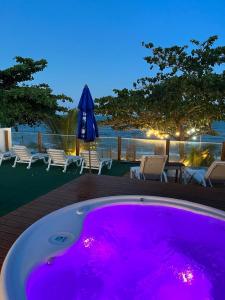 a large hot tub with purple lighting on a deck at Santorini Beach Hotel in Arraial d'Ajuda