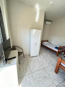 a room with a refrigerator and a bed in it at Pousada Quartos vcp in Viracopos