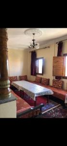 een woonkamer met een tafel en een bank bij Appartement lumineux et spacieux en plein centre ville in Ouarzazate