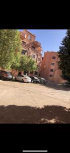 een straat met auto's geparkeerd voor een gebouw bij Appartement lumineux et spacieux en plein centre ville in Ouarzazate